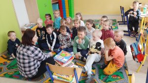 Tydzień Bibliotek 2022 w Filiach BPGZ (na zdjęciu przedszkolaczki ze SP w Płoskiem oglądają książeczki z ksiągozbioru biblioteki)